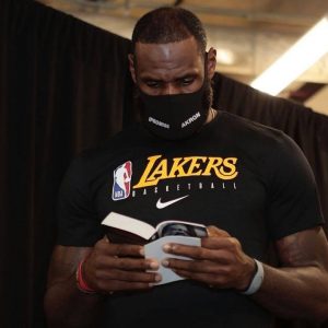 LeBron James walks down the tunnel reading a book, citing his enjoyment of reading. Mandatory Credit: Imagn Images