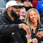 Mar 28, 2023; Houston, TX, USA; Los Angeles Laker LeBron James and his wife Savannah James sit court side at the McDonald's All American game during the first half at Toyota Center. Mandatory Credit: Maria Lysaker-USA TODAY Sports