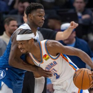 Oklahoma City Thunder guard Shai Gilgeous-Alexander (2) dribbles the ball past Minnesota Timberwolves guard Anthony Edwards (5) in the second half at Target Center.