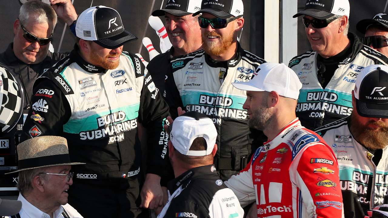 Sep 15, 2024; Watkins Glen, New York, USA; NASCAR Cup Series driver Chris Buescher (center) is congratulated by second place finisher driver Shane Van Gisbergen (right) in victory lane after winning the Go Bowling at The Glen at Watkins Glen International. Mandatory Credit: Matthew O'Haren-Imagn Images