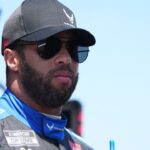 Aug 31, 2024; Darlington, South Carolina, USA; NASCAR Cup Series driver Bubba Wallace stands in his pit box prior to practice for the Cook Out Southern 500 at Darlington Raceway. Mandatory Credit: Jasen Vinlove-USA TODAY Sports