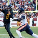 Washington Commanders quarterback Jayden Daniels (5) passes the ball as Chicago Bears defensive end Darrell Taylor (52) chases during the first quarter at Northwest Stadium.