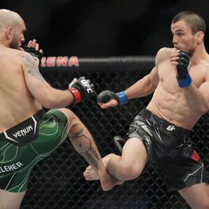 Brian Kelleher (red gloves) fights Umar Nurmagomedov (blue gloves) during UFC 272 at T-Mobile Arena.