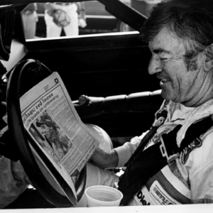 The defending Winston Cup points champion Bobby Allison checks out the newspaper during qualifying trials for the Nashville Pepsi 420 NASCAR Grand National race at Nashville International Raceway on July 13, 1984