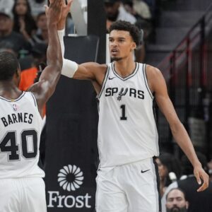 San Antonio Spurs center Victor Wembanyama (1) celebrates with San Antonio Spurs forward Harrison Barnes (40) in the first half at Frost Bank Center.