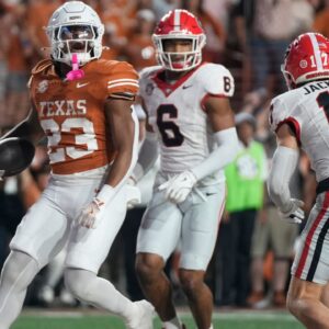 Texas Longhorns running back Jaydon Blue scores a touchdown against Georgia Bulldogs defensive back Daylen Everette (left) and defensive back Dan Jackson in the third quarter at Darrell K. Royal Texas Memorial Stadium.