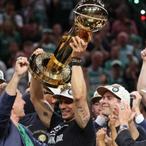 Boston Celtics head coach Joe Mazzulla holds up the trophy as he celebrates after winning the 2024 NBA Finals against the Dallas Mavericks at TD Garden.