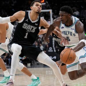 Minnesota Timberwolves guard Anthony Edwards (5) drives to the basket against San Antonio Spurs forward Victor Wembanyama (1) during the second half at Frost Bank Center.