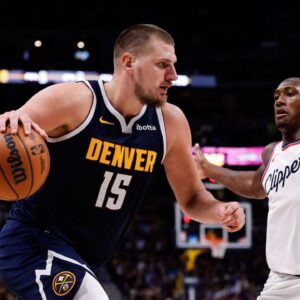 Denver Nuggets center Nikola Jokic (15) controls the ball as Los Angeles Clippers guard Kris Dunn (8) guards in the fourth quarter at Ball Arena.