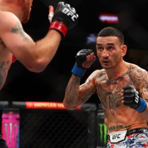 Max Holloway (blue gloves) fights Justin Gaethje (red gloves) during UFC 300 at T-Mobile Arena.