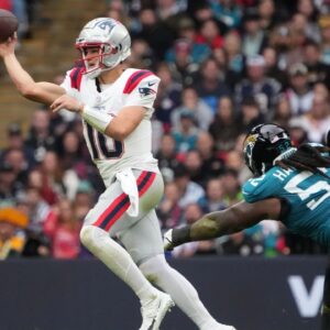 New England Patriots quarterback Drake Maye (10) throws the ball against Jacksonville Jaguars defensive tackle DaVon Hamilton (52) in the first half of an NFL International Series game at Wembley Stadium.