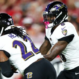 Oct 21, 2024; Tampa, Florida, USA; Baltimore Ravens quarterback Lamar Jackson (8) hands off to running back Derrick Henry (22) against the Tampa Bay Buccaneers in the first quarter at Raymond James Stadium.