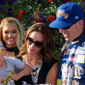 NASCAR Cup Series driver Kyle Busch and wife Samantha Busch watch as their son put the winner's sticker on his father's car after winning the Gander Outdoors 400 at Pocono Raceway.