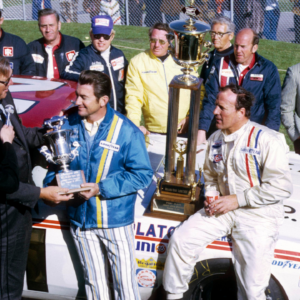 NASCAR Grand National Series driver Bobby Allison (left) receives the most popular driver award as A.J. Foyt (right) celebrates in victory lane after winning the inaugural 1971 Miller High Life 500 at Ontario Motor Speedway.