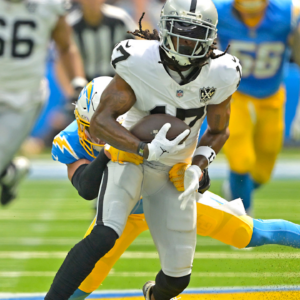 Las Vegas Raiders wide receiver Davante Adams (17) is stopped by Los Angeles Chargers safety Alohi Gilman (32) after a compete pass in the first half at SoFi Stadium.