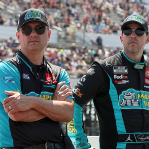 NASCAR Cup Series driver Denny Hamlin (right) stands with his crew chief Chris Gabehart (left) on pit road prior to The Great American Getaway 400 at Pocono Raceway.
