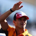 Lando Norris waves to fans during the driver's parade