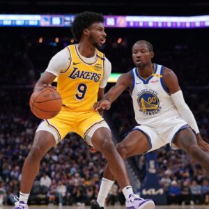 Los Angeles Lakers guard Bronny James (9) dribbles the ball next to Golden State Warriors forward Jonathan Kuminga (00) in the second quarter at the Chase Center.