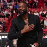 Former Miami Heat player Dwayne Wade acknowledges the fans and cameras after a special ceremony during halftime of the game between the Miami Heat and the Charlotte Hornets at Kaseya Center.