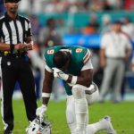 Miami Dolphins tight end Jonnu Smith (9) reacts on the field while training staff members attend to quarterback Tua Tagovailoa (1, not pictured) after an apparent injury during the second half against the Buffalo Bills at Hard Rock Stadium.