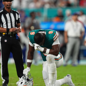 Miami Dolphins tight end Jonnu Smith (9) reacts on the field while training staff members attend to quarterback Tua Tagovailoa (1, not pictured) after an apparent injury during the second half against the Buffalo Bills at Hard Rock Stadium.