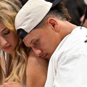 Kansas City Chiefs quarterback Patrick Mahomes (right) and his wife Brittany Mahomes (left) check their phone during the second half of the game between the Dallas Mavericks and the Minnesota Timberwolves in game three of the western conference finals for the 2024 NBA playoffs at American Airlines Center.