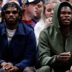 University of Colorado Buffaloes football players Shedeur Sanders (L) and Travis Hunter (R) watch during the third period between the Denver Nuggets and the Los Angeles Lakers at Ball Arena.