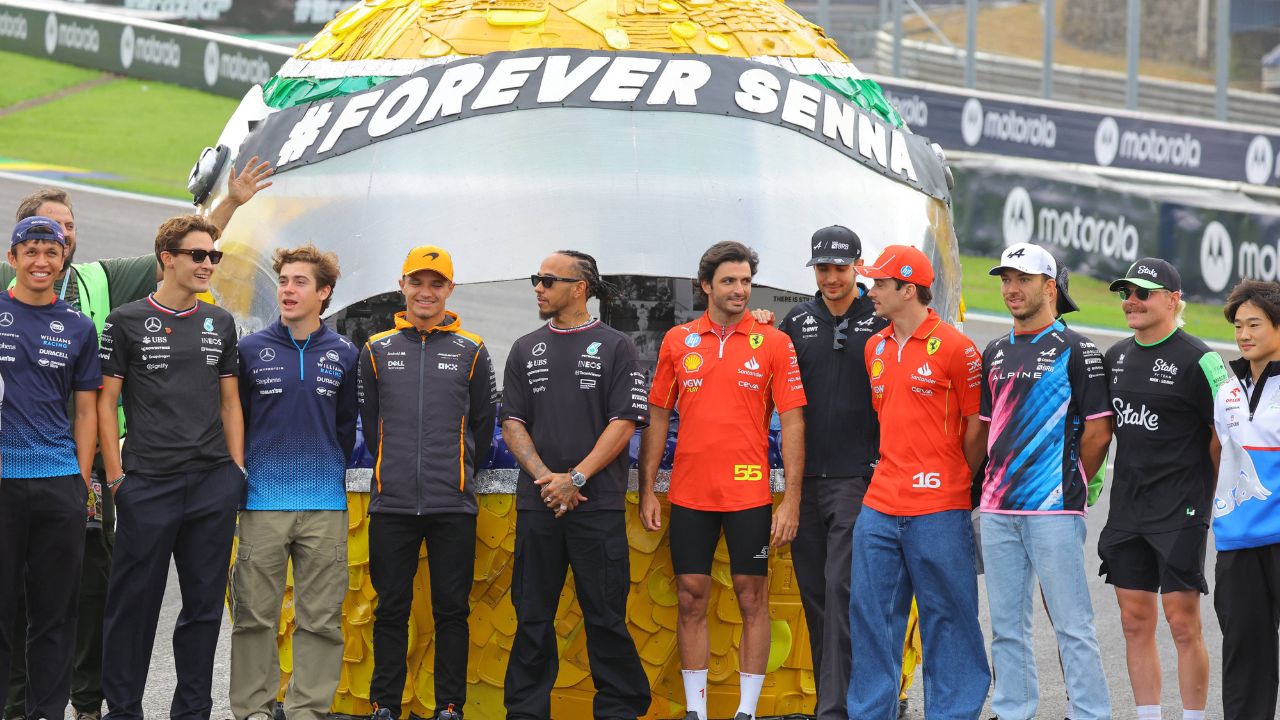 The Formula 1 drivers pose in front of a large helmet by Ayrton Senna Forever Senna Sao Paulo