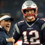 New England Patriots quarterback Tom Brady (12) talks with offensive coordinator Josh McDaniels before the start of the game against the Dallas Cowboys at Gillette Stadium.