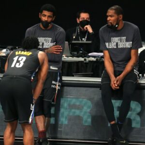 Brooklyn Nets point guard Kyrie Irving (C) and power forward Kevin Durant (R) talk to shooting guard James Harden (13) before checking into the game during the fourth quarter against the Los Angeles Clippers at Barclays Center.