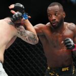 ; Leon Edwards (red gloves) fights Colby Covington (blue gloves) during UFC 296 at T-Mobile Arena.