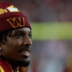 Injured Washington Commanders quarterback Jayden Daniels looks on from the sidelines against the Carolina Panthers during the third quarter at Northwest Stadium.