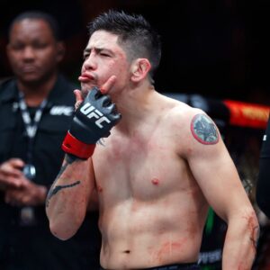 Brandon Moreno (red gloves) celebrates after defeating Amir Albazi (not pictured) in a flyweight bout during UFC Fight Night at Rogers Place.