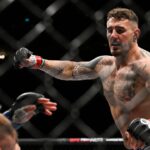 Tom Aspinall (red gloves) fights Marcin Tybura (blue gloves) during UFC Fight Night at O2 Arena.