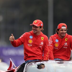 Ferrari's Spanish driver Carlos Sainz (R) and Monegasque driver Charles Leclerc react during the parade through the streets before the Formula One Mexico Grand Prix
