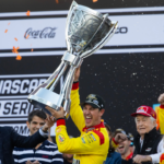 NASCAR Cup Series driver Joey Logano (right) is presented the Bill France Trophy by NASCAR president Steve Phelps after winning the 2024 NASCAR Cup Series championship and the NASCAR Cup Series Championship race at Phoenix Raceway.