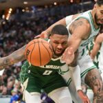 Milwaukee Bucks guard Damian Lillard (0) and Boston Celtics forward Jayson Tatum (0) reach for a loose ball in the second quarter at Fiserv Forum.