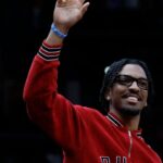Washington Commanders quarter back Jayden Daniels waves to the crowd from courtside during a timeout in the game between the Washington Wizards and Golden State Warriors in the first half at Capital One Arena.