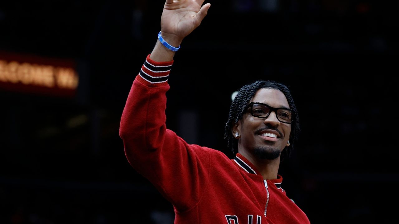 Washington Commanders quarter back Jayden Daniels waves to the crowd from courtside during a timeout in the game between the Washington Wizards and Golden State Warriors in the first half at Capital One Arena.