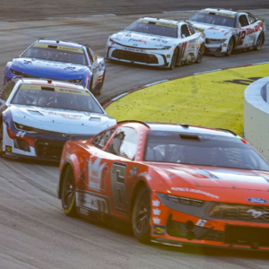 Cars leave turn two as the sun starts to set during the Xfinity 500 at Martinsville Speedway.
