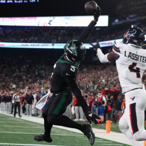 New York Jets wide receiver Garrett Wilson (5) catches a touchdown pass while being defended by Houston Texans cornerback Kamari Lassiter (4) during the second half at MetLife Stadium.
