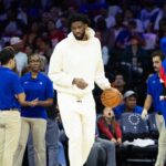 Philadelphia 76ers center Joel Embiid in plain clothes dribbles the ball during a timeout in the second quarter against the Milwaukee Bucks at Wells Fargo Center.