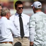 former NFL quarterback Tom Brady talks to Tampa Bay Buccaneers staff before a game against the San Francisco 49ers at Raymond James Stadium.