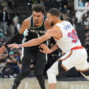 San Antonio Spurs center Victor Wembanyama (1) dribbles against Golden State Warriors guard Stephen Curry (30) in the first half at Frost Bank Center.