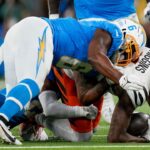 Los Angeles Chargers linebacker Denzel Perryman (6) drives into Cincinnati Bengals wide receiver Tee Higgins (5) as he is brought down in the first quarter of the NFL Week 11 game between the Los Angeles Chargers and the Cincinnati Bengals at SoFi Stadium.