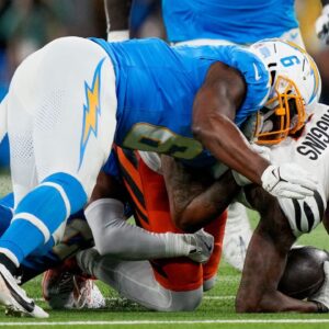 Los Angeles Chargers linebacker Denzel Perryman (6) drives into Cincinnati Bengals wide receiver Tee Higgins (5) as he is brought down in the first quarter of the NFL Week 11 game between the Los Angeles Chargers and the Cincinnati Bengals at SoFi Stadium.