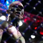 Israel Adesanya (blue gloves) reacts to defeating Alex Pereira (red gloves) during UFC 287 at Miami-Dade Arena.