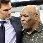 (L ro R) Fox Sports commentator Tom Brady and boxer Mike Tyson pose for a photo on the field before a game between the New Orleans Saints and Dallas Cowboys at AT&T Stadium.