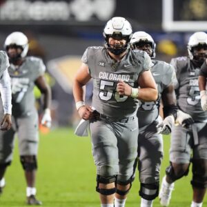 Colorado Buffaloes quarterback Shedeur Sanders (2) and Colorado Buffaloes center Hank Zilinskas (58) stay warm in the fourth quarter against the Cincinnati Bearcats at Folsom Field.