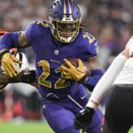 Baltimore Ravens running back Derrick Henry (22) rushes as Cincinnati Bengals safety Jordan Battle (27) and linebacker Joe Bachie (49) defends during the second half at M&T Bank Stadium.